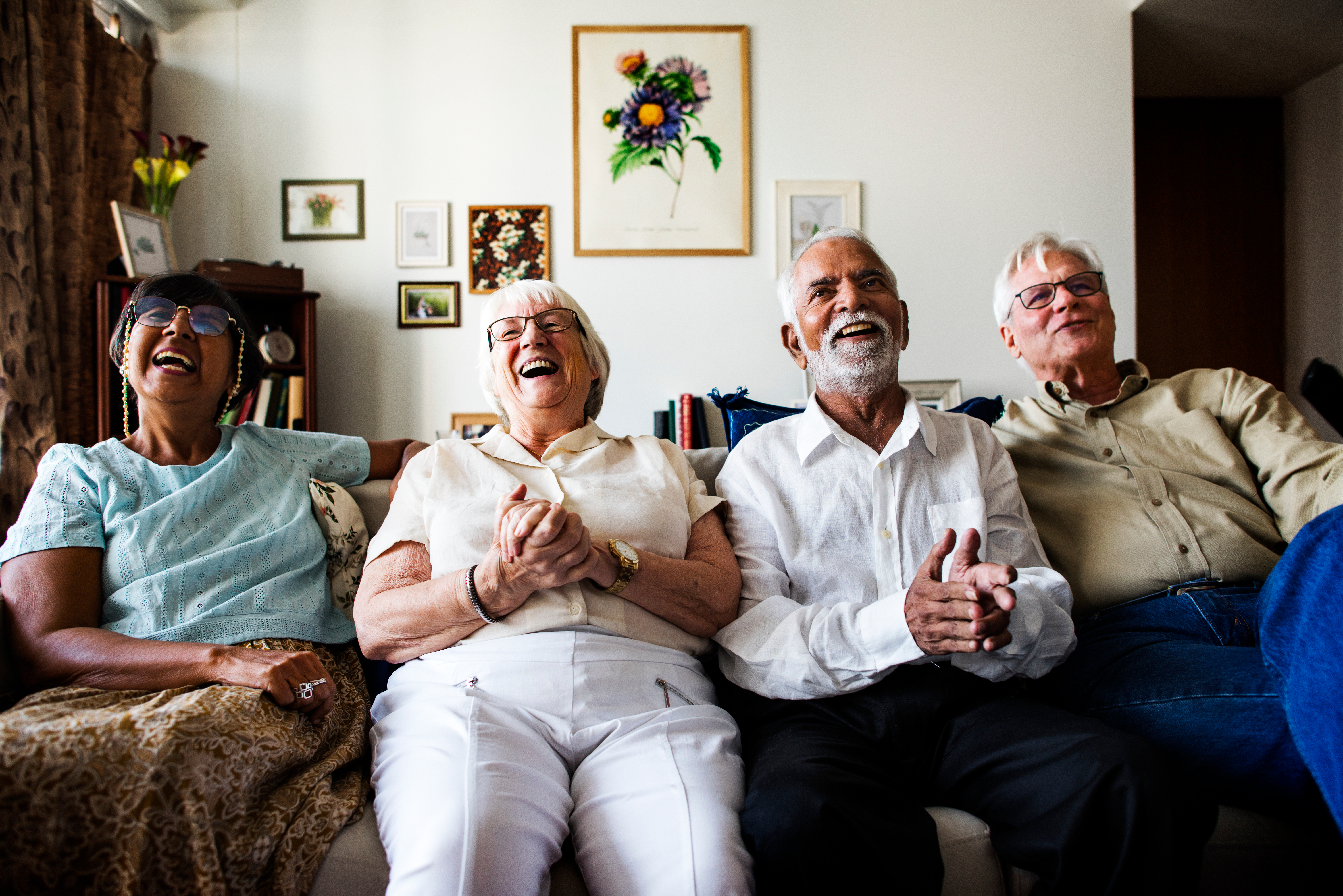 Neljä iäkästä ihmistä katsomassa elokuvaa iloissaan.